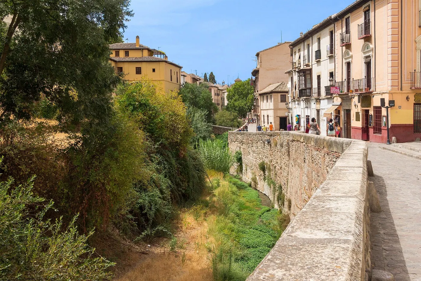 Muro de piedra junto al cauce del río Darro y fachadas de la Carrera del Darro