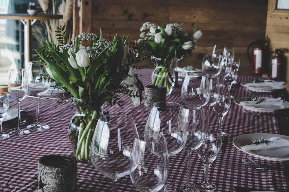 Mesa larga con centros de flores y copas en un banquete de boda en Granada