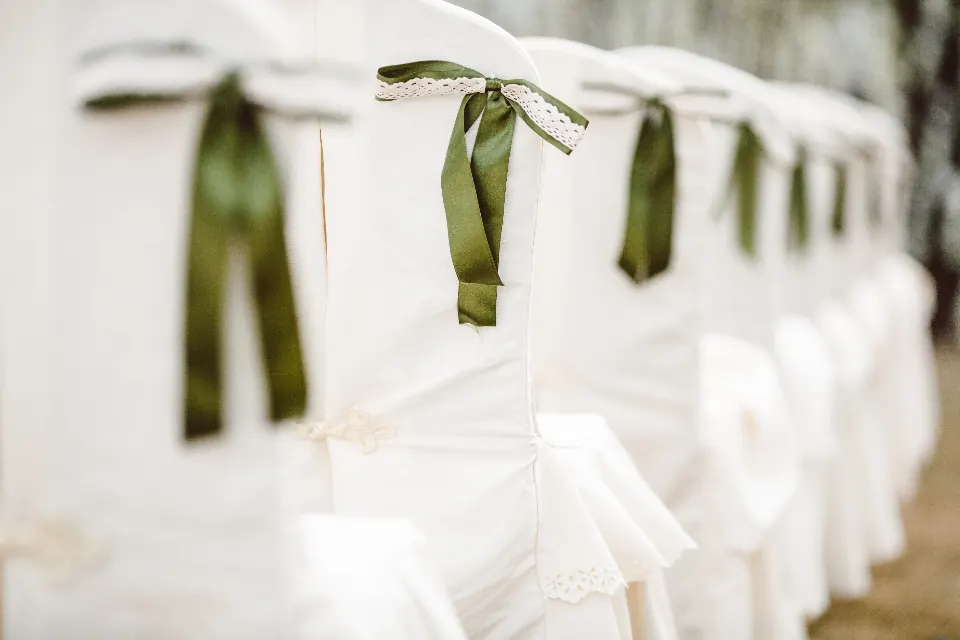Sillas blancas con lazos verdes para una boda en un cortijo de la Vega de Granada