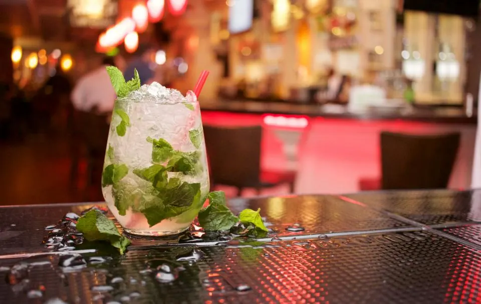 Cóctel tipo mojito en una barra con luces en una fiesta privada en Granada