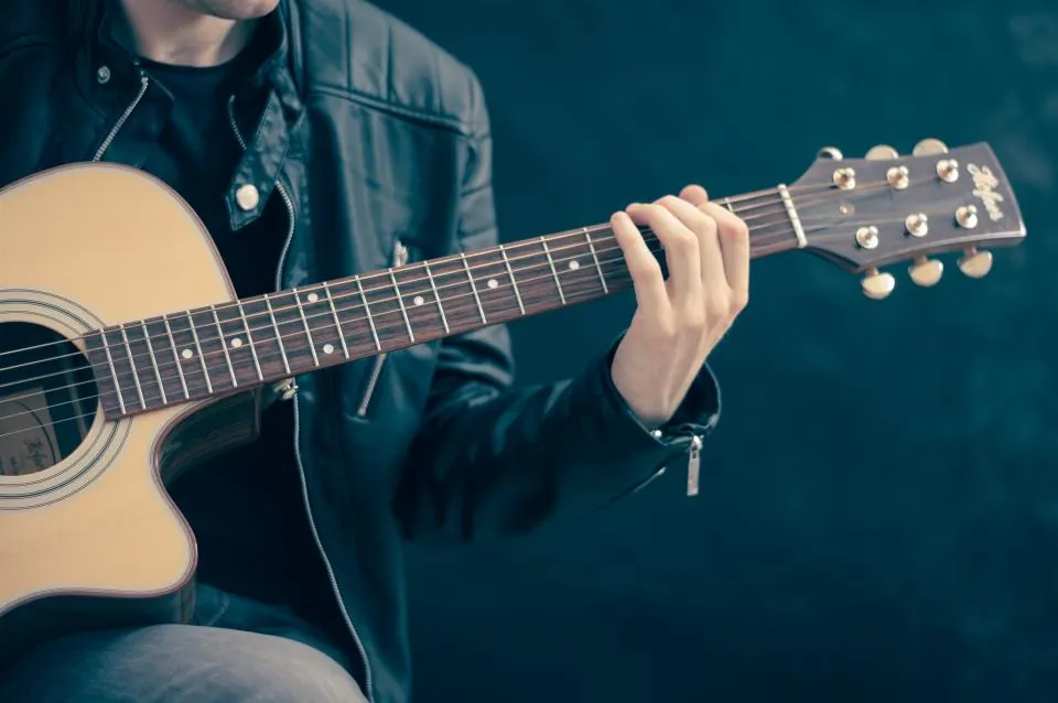 Manos tocando una guitarra española, el flamenco y la zambra de Granada