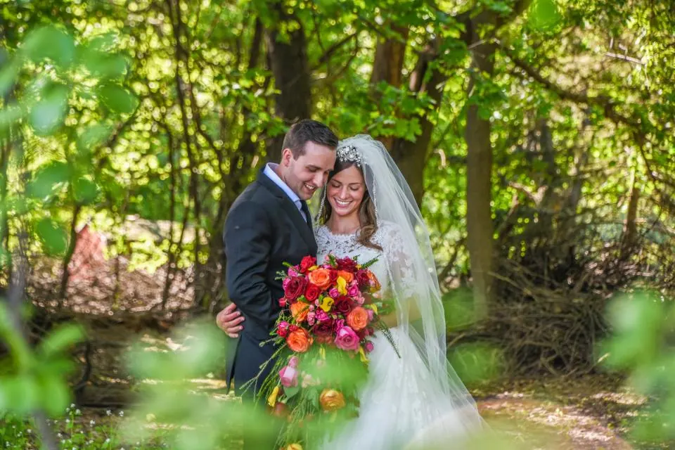 Novios abrazados con el ramo en un bosque, bodas en Granada